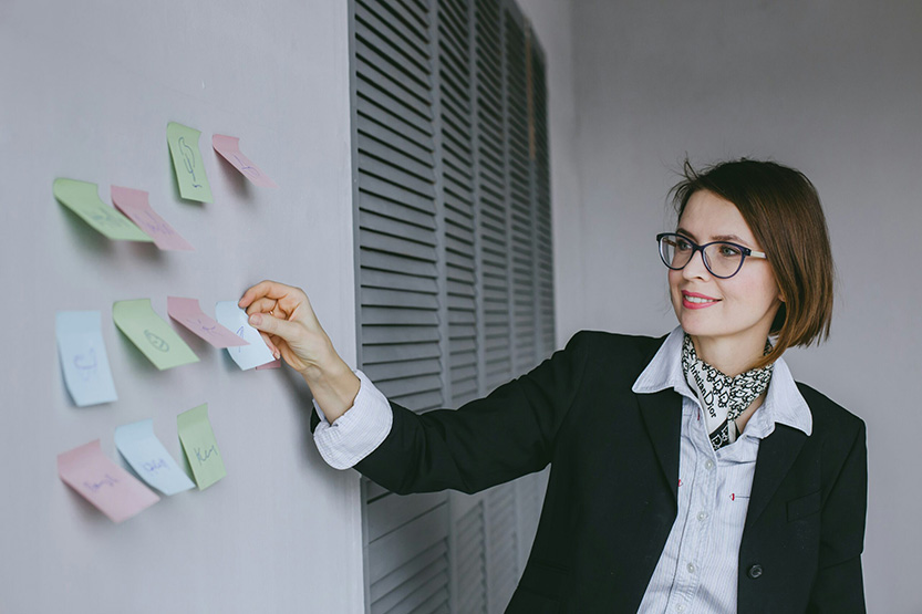 business and digital marketing coach puts sticky notes on wall